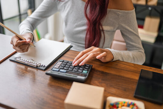 Woman managing small business accounts and recording sales revenue and expenses business income financial management entrepreneurship .