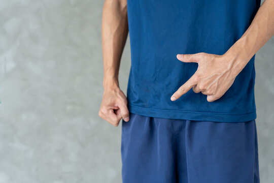 Man hold hand in front of private parts feeling discomfort from disease and inflammation. Venereal, testicular cancer. bladder problems, erectile dysfunction, premature ejaculation, prostate cancer