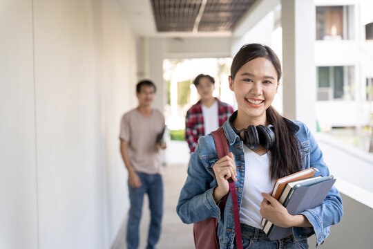 Portrait beautiful Asian woman student. Smile girl happy study. Hold book on the head college campus. young female on international Asia University. Education, study, school, learning, exam.