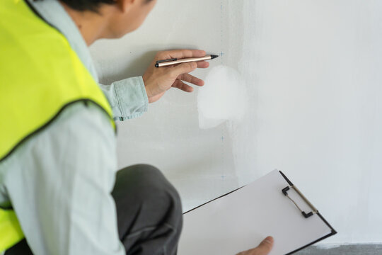 inspector or engineer is inspecting construction and quality assurance new house using a checklist. Engineers or architects or contactor work to build the house before handing it over to the homeowner