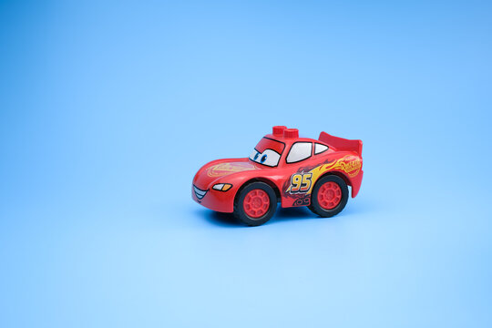 A Lightning McQueen toy car is photographed from a front three-quarter angle on a light blue background, highlighting the smiling face and racing decals on Jul 29, 2026 in Jakarta, Indonesia.