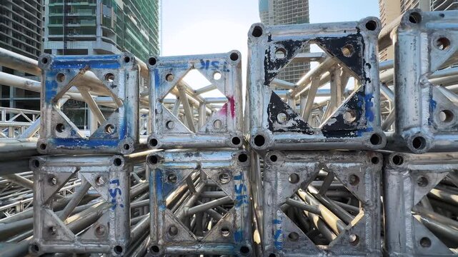 Close up of Frame Tent Corner Connector Plates Truss Stacked and sun backlit. Cinematic motion shot