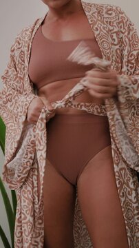 Close up of woman wearing luxury kimono robe over  swimsuit.