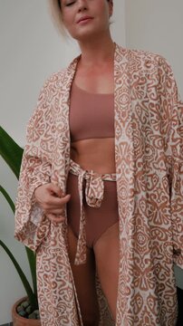 Close up of woman wearing luxury kimono robe over  swimsuit.