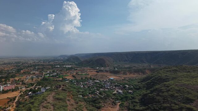 Aerial drone view of Nuh district in Haryana, India with Aravalli Hills and dramatic monsoon clouds in 4K