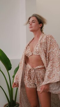 Woman wearing coordinated kimono robe with matching bralette and lounge shorts.