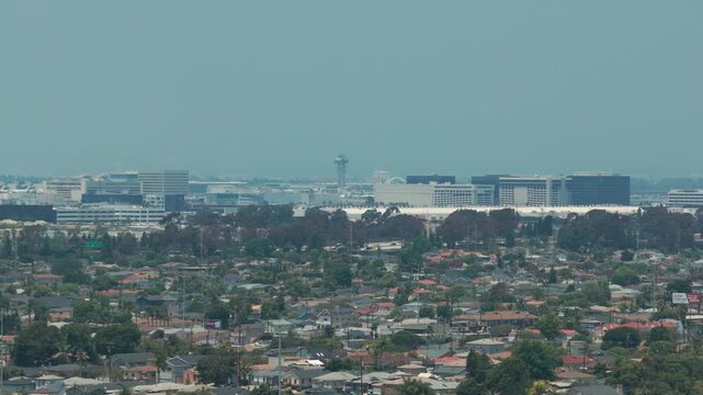 Telephoto aerial dolly shot of LAX on a hazy day from Hawthorne, California. 4K