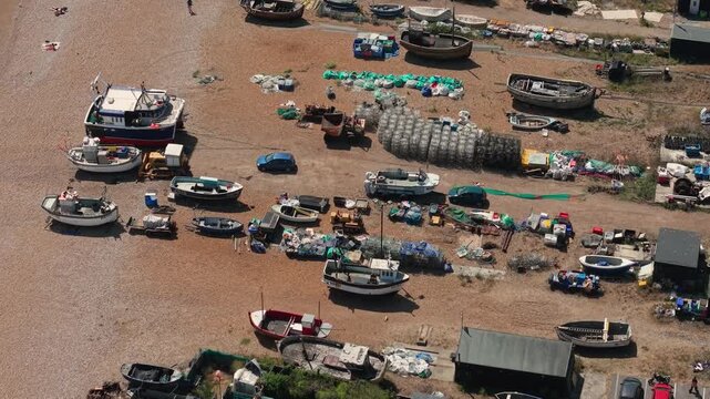Left aerial pan glides over traditional fishing boats on Hastings Stade before sweeping across the shoreline and out to sea.