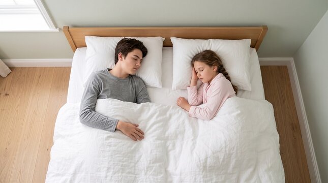 A young brother and sister sleeping peacefully in a comfortable bed together during the night time as they enjoy rest and relaxation in their cozy bedroom while covered by warm soft cotton
