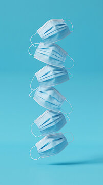 Vertical stack of floating blue surgical face masks on solid light blue background for pandemic protection and healthcare hygiene conceptual imagery for medical safety information.