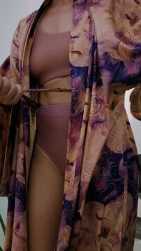 Close up of woman wearing luxury kimono robe over  swimsuit.