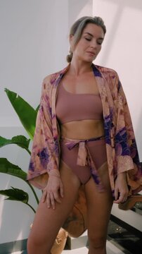 Close up of woman wearing luxury kimono robe over  swimsuit.