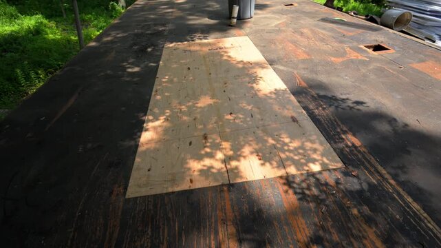 New plywood roof sheathing installed during a residential roof repair project. Fresh roof deck patch prepared for underlayment and new shingles