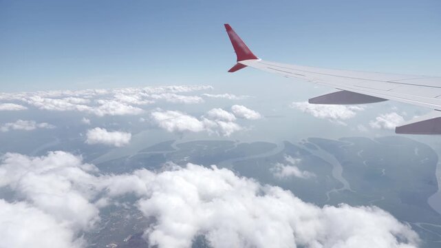 view inside airplane aircraft through window with wing view while flying in sky over puffy cloudy and blue sea ocean in sunny day,Airplane Wings with blue sky travel vacation holiday background