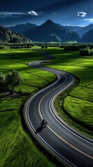 Obraz premium Winding Asphalt Road Through Lush Green Fields with Distant Majestic Mountains Under Dramatic Sky