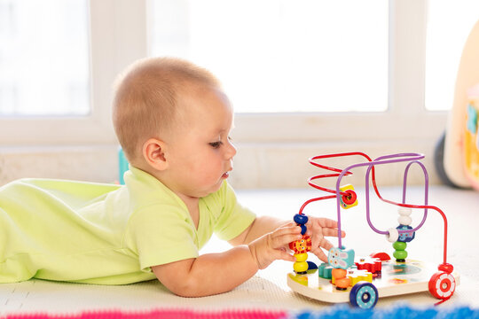 Infant Boy Practices Fine Motor Skills With Bead Maze