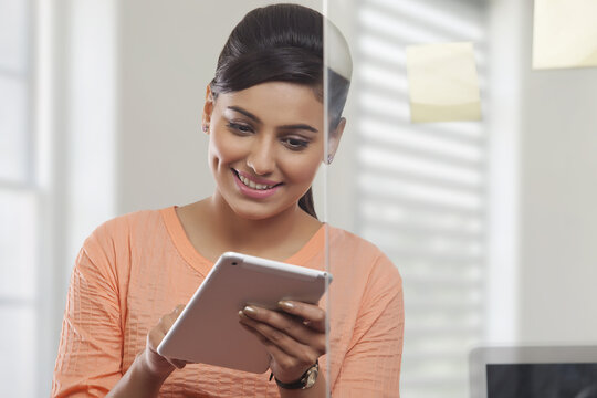 Portrait of smiling woman using digital tablet in office