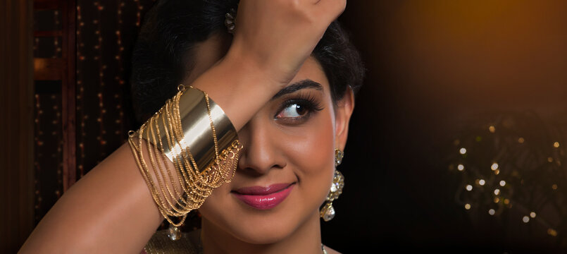 Close-up portrait of  young woman posing with bracelet hand on head
