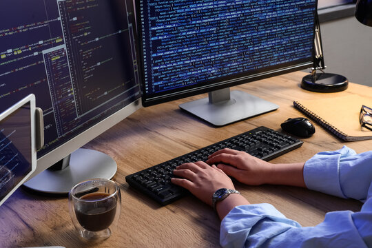 Programmer hands typing on a keyboard with multiple computer screens displaying code software development and IT, this setup software development information technology and data analysis concepts
