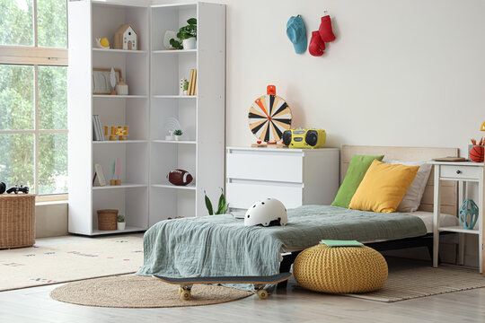 Modern teenagers bedroom with a single white shelving unit skateboard and colorful decor for a comfortable living space