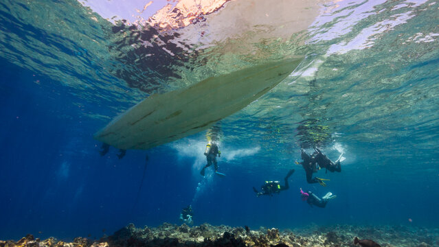 Underwater shot of Dive boat and SCUBA Divers above a reef in the Palau Marine Sanctuary