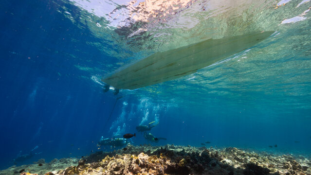 Underwater shot of Dive boat and SCUBA Divers above a reef in the Palau Marine Sanctuary