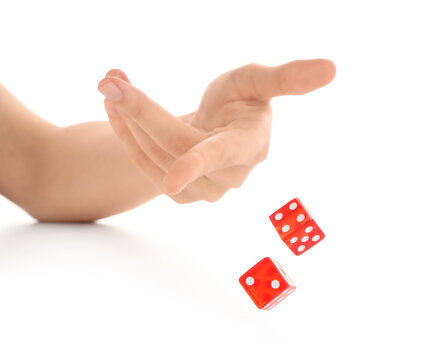 Female hand throwing two red game dices on white background