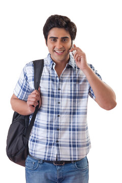 Smiling male college student using mobile phone