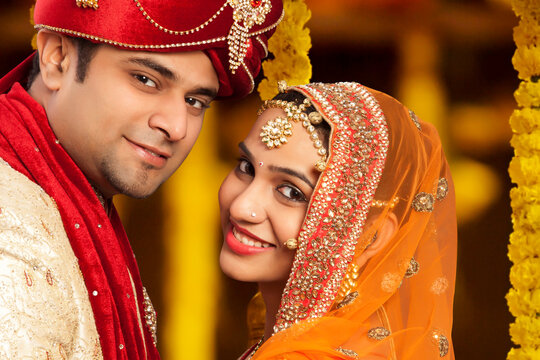 Handsome groom and beautiful bride looking at camera ,young couple