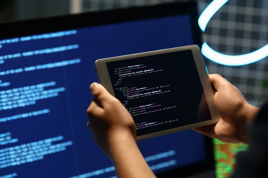 Programmers hands with modern tablet computer in office, closeup