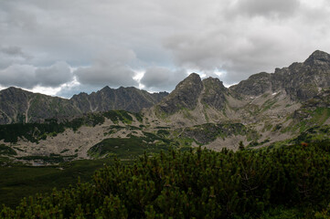Rugged mountain range under a dramatic cloudy sky © Cavan