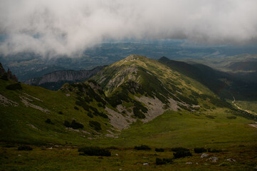 Cloudy skies over a lush green mountain range © Cavan