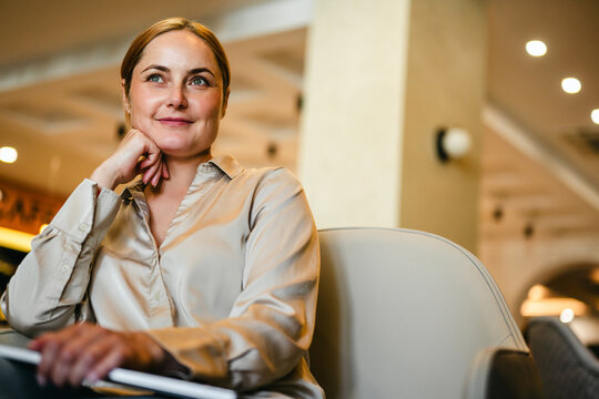Smiling woman working remotely in a caffe, copy space