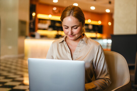 Businesswoman working on her laptop in a modern cafe