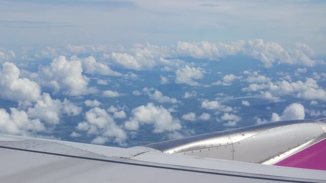 view inside airplane aircraft through window with wing view while flying in sky over puffy cloudy in sunny day,Airplane Wings with blue sky travel vacation holiday background