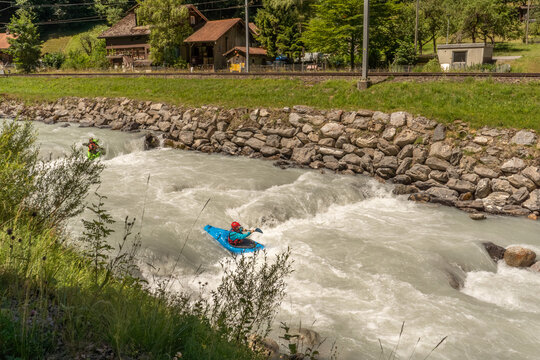 Whitewater kayaking on a glacier-fed river with powerful currents, splashing water, and dramatic outdoor adventure scenery.