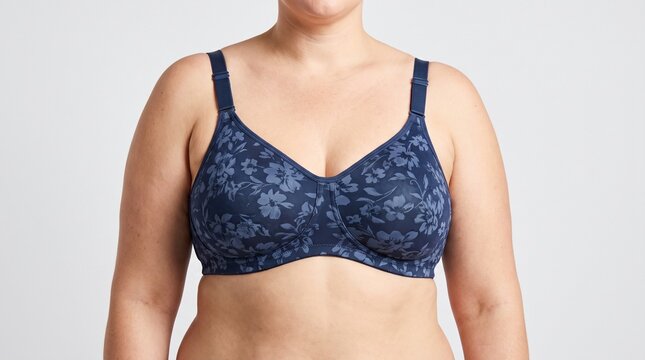 Plus-size woman wearing floral patterned blue bra in studio setting