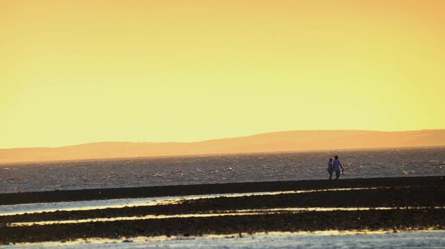 Couples sunset walk on Morecambe bay