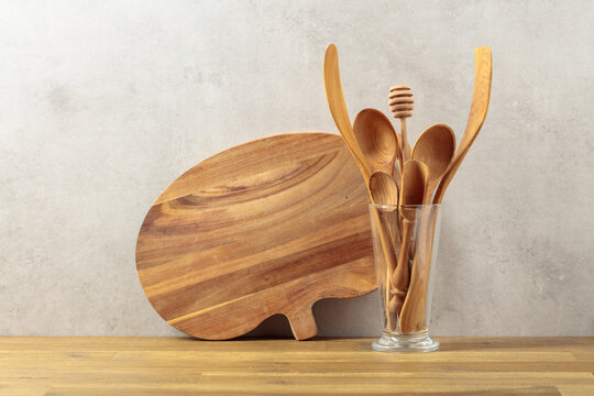 Wooden kitchen utensils on a wooden table.