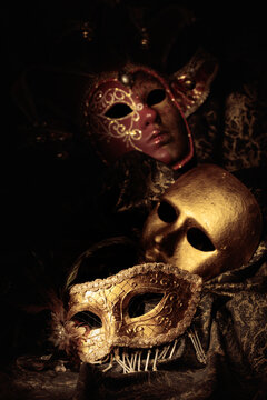 Golden carnival masks on a dark background.