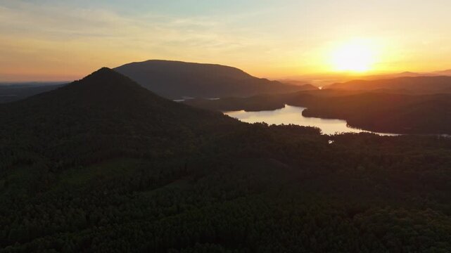 Sunrise light spreads across forested ridges and a lake in Tennessee.