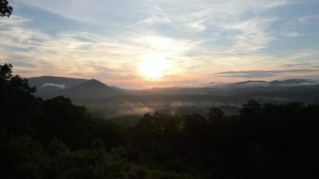 Aerial sunrise over misty Appalachian mountain ridges and valleys in Tennessee.