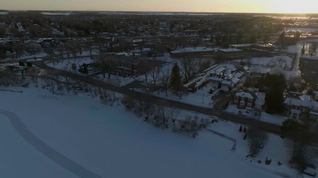 drone flying over the coastline of river richgelieau in winter exposing the bigest church in the chambly towars the lighthouse