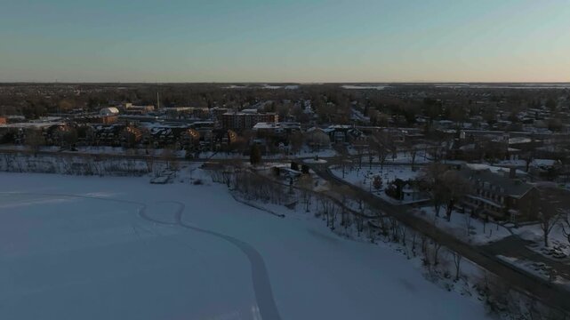 drone flying over the coast line of the river richelieau in chambly exposing the main entry to the city n the city hall n library in winter even the lighthouse
