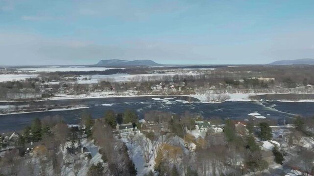 drone almost doing a 360 rotation showing the oldest part of the city of chambly in quebec canada in winter from the bridge to the fort chambly