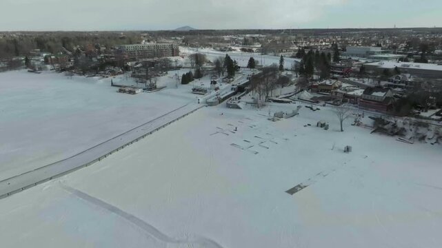 drone zooming out from channel chambly in winter overlooking all the structure in river richelieau in the marina