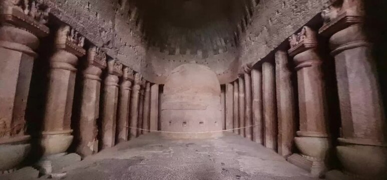 Historic Stone Stupa Surrounded by Carved Columns Inside Low Lit Chaitya Prayer Hall at Kanheri Caves, Maharashtra