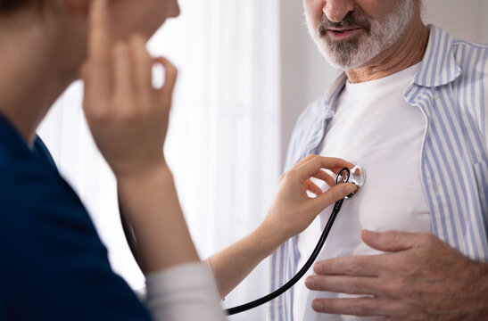 A private healthcare worker for an elderly man uses a digital tablet to monitor the patient's health at home, providing care and checking his physical condition.