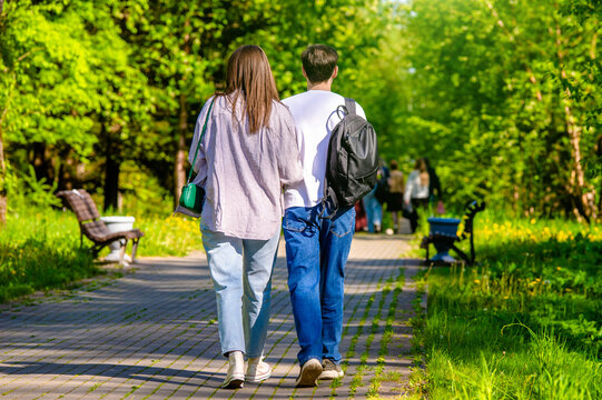 A guy and a girl walk along the path in the city Park