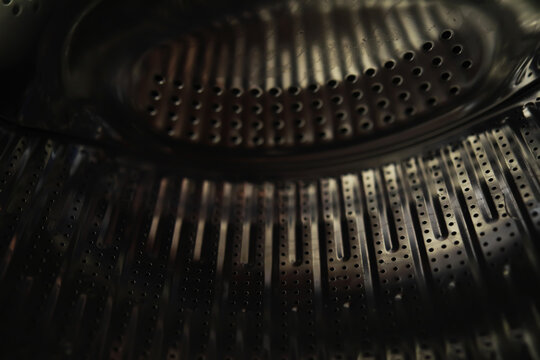 Close-up of Washing Machine Drum with Metallic Surface and Circular Holes